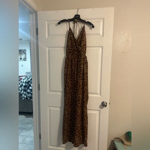 Junpsuit is maroon with yellow/gold flowers and green vines.